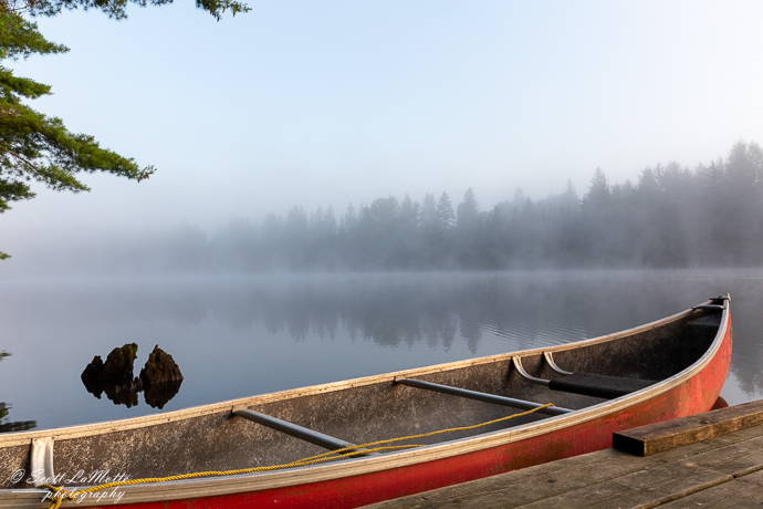 Row boat on a misty lake, Ontario.