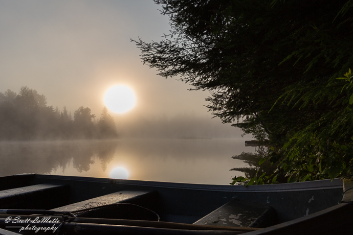Row boat on a lake, misty morning.